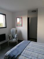 a bedroom with a bed and a chair and a window at F2 Blanc Bleu in Sainte-Marie-la-Mer