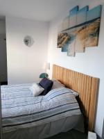 a bed in a bedroom with paintings on the wall at F2 Blanc Bleu in Sainte-Marie-la-Mer