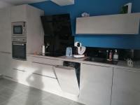 a kitchen with white cabinets and a blue wall at F2 Blanc Bleu in Sainte-Marie-la-Mer