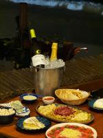 ein Tisch voller Teller mit Speisen und Flaschen Wein in der Unterkunft Pousada Belas Águas in Praia de Araçatiba