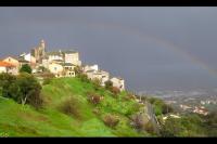 a castle on top of a hill with a rainbow at Appartement d&#39;une chambre avec terrasse et wifi a Furiani a 3 km de la plage in Furiani