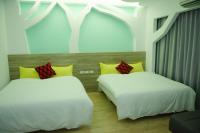two beds with yellow and red pillows in a room at Apple Tree Bed and Breakfast in Hualien City
