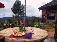 Una mesa con un plato de plátanos y un vaso de leche. en Mu Cang Chai Eco Lodge, en Nam San