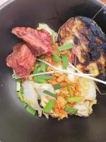 un tazón negro de comida con carne y verduras en La Petite Porte Verte, en Bouilland