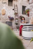 a woman sitting in a barrel looking at a magazine at Leukòs Bed and Breakfast in Castelsaraceno