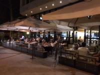 een restaurant met mensen aan tafels onder parasols bij Andes Suites in Santiago