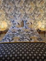 a bed with a black and white bedspread with birds on it at Chez Aurélie et Bruno in Montceau-les-Mines