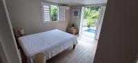 a bedroom with a bed and a door to a patio at LOCATION LA MONTAGNE MARTINIQUE in Le Vauclin