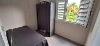 a room with a bed and a window and a swing at LOCATION LA MONTAGNE MARTINIQUE in Le Vauclin