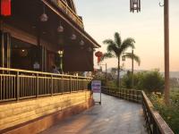 a sidewalk outside of a restaurant with a palm tree at Suksomboonhotel in Loei