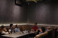 a group of people sitting at tables in a restaurant at My Home Hotel Pontianak in Pontianak