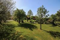 a green yard with trees and a house at Gîte de France Bayat 4 épis - Gîte de France 5 personnes 354 in Varetz