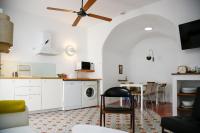 a kitchen with white cabinets and a washer and dryer at Vejerísimo Casa Boutique in Vejer de la Frontera