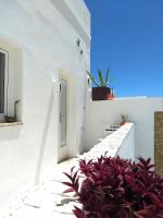 a white house with white walls and purple flowers at Vejerísimo Casa Boutique in Vejer de la Frontera