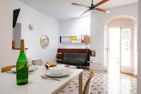 a white living room with a table with a wine bottle at Vejerísimo Casa Boutique in Vejer de la Frontera