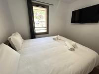 a bedroom with a white bed with towels on it at Résidence LES TERRASSES DE LA VANOISE - Appartement LES TERRASSES DE LA VAN 924 in Champagny-en-Vanoise