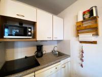 eine kleine Küche mit einer Spüle und einer Mikrowelle in der Unterkunft Résidence Grande Chaume - 2 Pièces pour 6 Personnes 424 in Vénosc