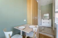 a dining room with a wooden table and white chairs at Hamac Suites - Monplaisir fully equipped studio-2p in Lyon