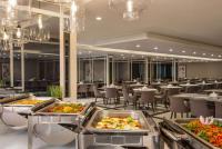 メッカにあるRamada by Wyndham Makkah Zad Al Tayseerの食品のトレイが並ぶレストラン