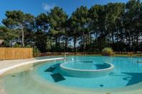 a large swimming pool in a yard with trees at Résidence Lacanau Les Pins - maeva Home - Appartement 2 Pièces 5 Personnes 27 in Lacanau