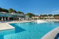 a swimming pool at a resort with chairs and umbrellas at Résidence Lacanau Les Pins - maeva Home - Appartement 2 Pièces 5 Personnes 27 in Lacanau