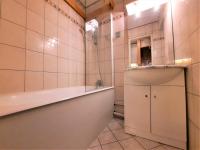 a bathroom with a tub and a sink at Résidence Chaviere - Studio pour 2 Personnes 034 in Les Menuires