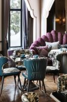 a room with purple couches and tables and chairs at Hotel Sosei Sapporo MGallery Collection in Sapporo