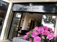 a pot of pink flowers in front of a store at Tiercé Hotel in Cagnes-sur-Mer