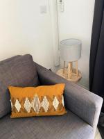 a gray couch with an orange pillow and a table at Les Jonquières - maeva Home - Appartement 2 pièces 4 personnes - Confort 554 in Gassin