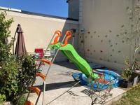 a green slide in a backyard with a pool at Propriete de 2 chambres avec terrasse et wifi a Saint Denis in Saint-Denis