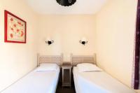 two beds in a room with white walls at Les Coteaux de Pont Royal en Provence - maeva Home - Appartement 3 pièces 6 214 in Mallemort