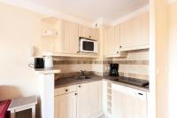 a kitchen with white cabinets and a microwave at Les Coteaux de Pont Royal en Provence - maeva Home - Appartement 3 pièces 6 214 in Mallemort