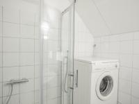 a white washing machine in a white tiled bathroom at Villa Campagne 138 in Daumazan-sur-Arize