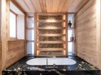 a bathroom with a tub in a room with wooden walls at Résidence Beloukha - Chalets pour 12 Personnes 734 in Saint-Bon-Tarentaise