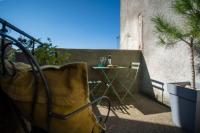 a balcony with a table with a bottle of wine at Lovely house with courtyard and terrace near canal du Midi in Trèbes