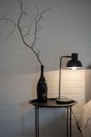 a lamp and a vase on a table next to a bed at Lovely house with courtyard and terrace near canal du Midi in Trèbes