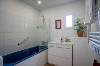 a bathroom with a blue tub and a sink at Lovely house with courtyard and terrace near canal du Midi in Trèbes