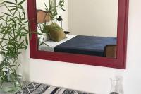 a mirror on a wall with a bed in a room at Lovely house with courtyard and terrace near canal du Midi in Trèbes