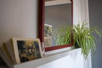 a mirror on a shelf with a plant and a book at Lovely house with courtyard and terrace near canal du Midi in Trèbes