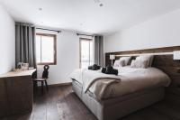 a bedroom with a large bed and a desk at Résidence Le Bercail - Chalets pour 12 Personnes 224 in Saint-Martin-de-Belleville