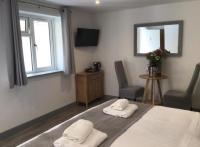 Un dormitorio con una cama y dos sillas y un televisor. en Hunters Lodge, en Barnstaple