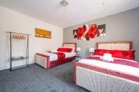 two beds in a room with red pillows at *RB10W* For your most relaxed &amp; Cosy stay + Free Parking + Free Fast WiFi * in Belle Isle