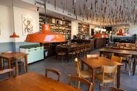 an empty restaurant with wooden tables and chairs at Locanda della Masseria a Porza, Lugano in Porza