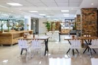 un ristorante con tavoli in legno e sedie bianche di Akdeniz Yaşam Otel a Silifke