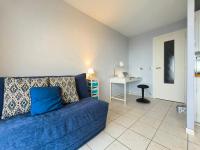 ein Wohnzimmer mit einem blauen Sofa und einem Schreibtisch in der Unterkunft Studio 2 Personnes -- Vue Port de Comberge ! in Saint-Michel-Chef-Chef