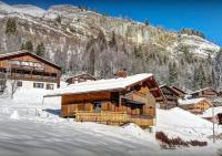 a log cabin in the snow in front of a mountain at Chalet Sicoria - Les Congères in Le Grand-Bornand