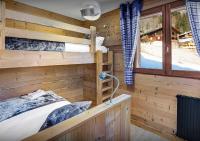 a bedroom with two bunk beds in a log cabin at Chalet Sicoria - Les Congères in Le Grand-Bornand