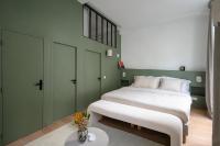 a bedroom with a large white bed and green walls at Noble Suites in Paris