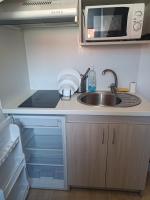 eine kleine Küche mit einer Spüle und einer Mikrowelle in der Unterkunft Résidence de l&#39;Alliance in Nizza