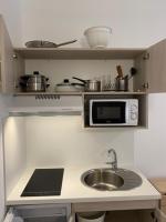 eine kleine Küche mit einer Spüle und einer Mikrowelle in der Unterkunft Résidence de l&#39;Alliance in Nizza